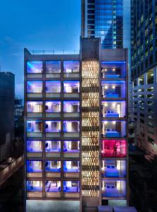 バンコクにあるS ボックス スクンビット ホテル - SHA Extra Plusの夜間照明付きの高層ビル