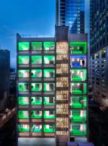 a tall building with green lights on it at S Box Sukhumvit Hotel - SHA Extra Plus in Bangkok