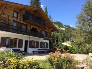a house with a balcony and a table and an umbrella at Outstanding chalet for groups, south facing, breathtaking views - all year round in Anzère