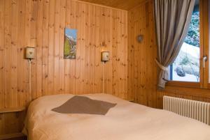 - une chambre avec un lit dans un mur en bois dans l'établissement Outstanding chalet for groups, south facing, breathtaking views - all year round, à Anzère