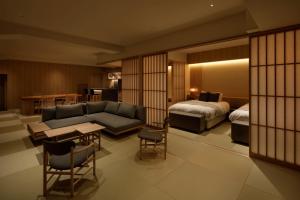 a hotel room with a couch and a bed at 会津東山温泉　鶴我東山総本山 in Aizuwakamatsu