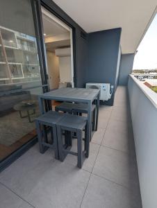 a table and benches in a room with a window at Newcastle Harbourside Terraces in Newcastle