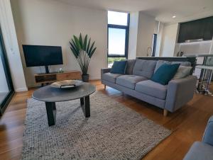 sala de estar con sofá y mesa en Newcastle Harbourside Terraces, en Newcastle