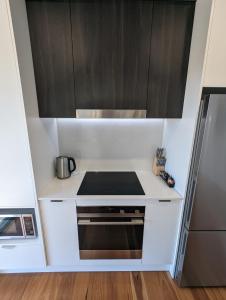 a small kitchen with a stove and cabinets at Newcastle Harbourside Terraces in Newcastle