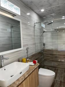 W łazience znajduje się umywalka, toaleta i prysznic. w obiekcie Khách sạn Khang An Buôn Ma Thuột w mieście Buôn Ma Thuột