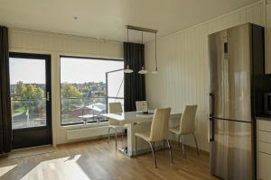 uma cozinha com mesa e cadeiras e uma grande janela em Two bedroom apartment, top floor, stunning views em Eidsvoll