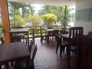 een restaurant met tafels en stoelen en een balkon bij PEDRO'S RESORT in Panglao