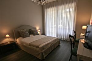 a hotel room with a bed, desk, chair and lamp at Milano Brera Relais in Milan