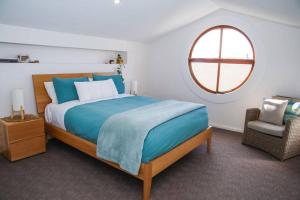 Un dormitorio con una cama grande y una ventana en 12 Rocks Beach View Loft Central Port Campbell, en Port Campbell
