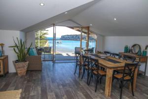 une salle à manger avec une table et des chaises et l'océan dans l'établissement 12 Rocks Beach View Loft Central Port Campbell, à Port Campbell