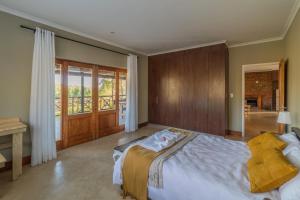 a bedroom with a large bed and a balcony at Lekkerkry in Plettenberg Bay