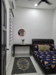 a room with a bed and a table and a mirror at AR Homestay Bukit Kuang Kemaman in Cukai