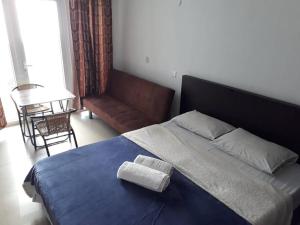 a bedroom with a large blue bed with two towels on it at Ocean Drive Studio, next to the Beach in Grand-Baie