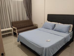 een slaapkamer met een bed en een stoel erin bij Hyve Soho Suite - Netflix in Cyberjaya