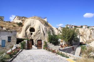 a stone path leading to a cave with a door at CAPPADOCİA ST.NİNO'S GARDEN in Ortahisar