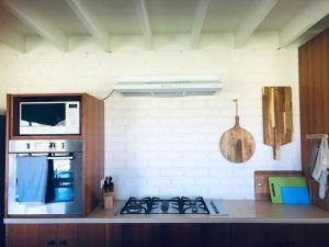uma cozinha com um fogão e um micro-ondas em Peterborough Beach House em Peterborough