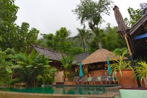 un complejo con piscina, sillas y árboles en Mandala Ou Resort, en Nongkhiaw