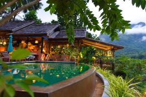 a resort with a swimming pool in front of a house at Mandala Ou Resort in Nongkhiaw