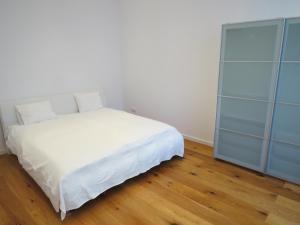 sypialnia z białym łóżkiem i niebieską szafką w obiekcie Apartments Alserstraße w Wiedniu