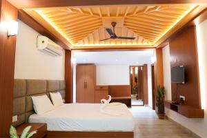 1 dormitorio con 1 cama con un cisne en el techo en Aranya Jungle Resorts, en Lataguri