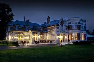 Une grande maison éclairée la nuit dans l'établissement Le Domaine des Roches, Hotel & Spa, à Briare