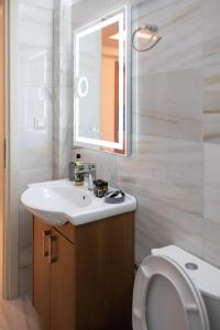 een badkamer met een wastafel, een spiegel en een toilet bij Patras Casale in Patra