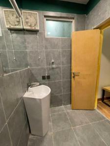 a bathroom with a toilet and a door at Eat and Read Hotel in Skardu