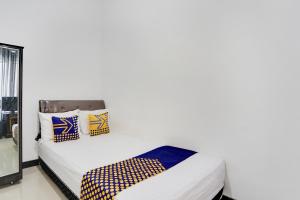 Postel nebo postele na pokoji v ubytování SPOT ON 91745 Rumah Kost Gresik Syariah