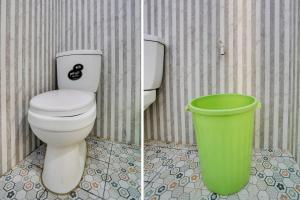 een badkamer met een toilet en een groene vuilnisbak bij SPOT ON 91745 Rumah Kost Gresik Syariah in Gresik