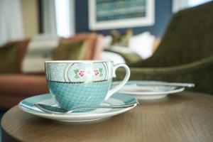 a coffee cup and saucers on a wooden table at The Langlands Hotel in Invercargill