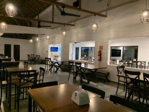a restaurant with wooden tables and chairs and lights at Mar De Estrellas - Hotel in Costa Esmeralda