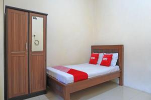 a bedroom with a bed with red pillows on it at OYO 91762 Green Home Stay Syariah 