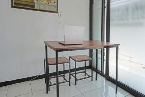 a table with a laptop computer on top of it at OYO 91762 Green Home Stay Syariah 