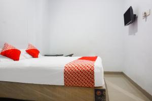 Un pat sau paturi într-o cameră la OYO 91759 Pondok Hikmah Makassar