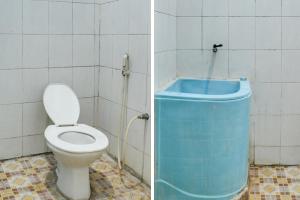 y baño con aseo y bañera azul. en OYO 91769 Wisma Harapan Baik, en Kupang