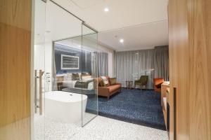 a hotel room with a tub and a living room at The Langlands Hotel in Invercargill
