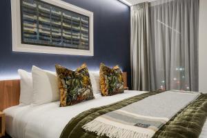 a bedroom with a large white bed with pillows at The Langlands Hotel in Invercargill