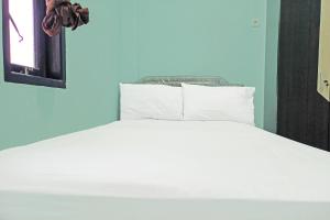 Ένα ή περισσότερα κρεβάτια σε δωμάτιο στο SPOT ON 91791 Homestay Surya Syariah