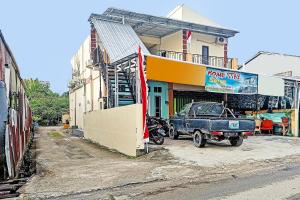 een blauwe truck geparkeerd voor een gebouw bij SPOT ON 91791 Homestay Surya Syariah in Tarakan