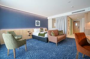 a hotel room with a bed and two chairs at The Langlands Hotel in Invercargill