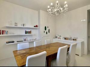 a dining room table with white chairs and a chandelier at B&B Campesio al2 in Piacenza