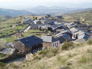 uma aldeia no topo de uma colina com casas em Hostal Rural La Casa del Peregrino em El Acebo de San Miguel