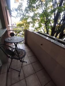 d'un balcon avec une table, des chaises et une fenêtre. dans l'établissement Apartman Lipa, à Slavonski Brod