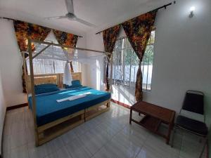 een slaapkamer met een bed, een stoel en ramen bij L&J Modern Backpackers Kigamboni Beach House in Dar es Salaam
