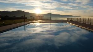 a swimming pool with the sun in the sky at Hostal Rural La Casa del Peregrino in El Acebo de San Miguel