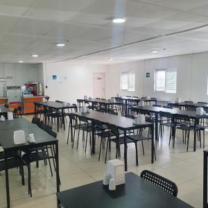 an empty room with tables and chairs in it at Apec Hotel in Atyraū