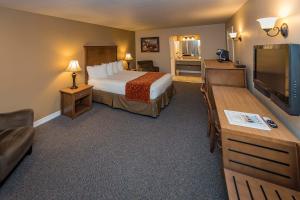 a hotel room with a bed and a flat screen tv at Mill Village Motel in Eatonville