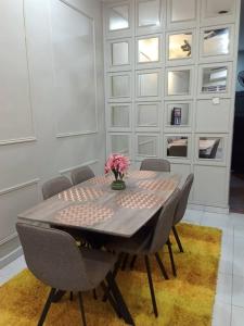 a dining room table with chairs and a vase of flowers at AR Homestay Bukit Kuang Kemaman in Cukai