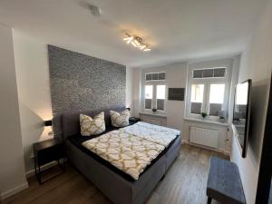 a bedroom with a large bed and two windows at Cityapartments am Hafen in Waren
