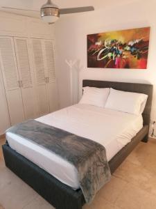 Bett in einem Schlafzimmer mit Wandgemälde in der Unterkunft Cabrero Beach 1111 in Cartagena de Indias
